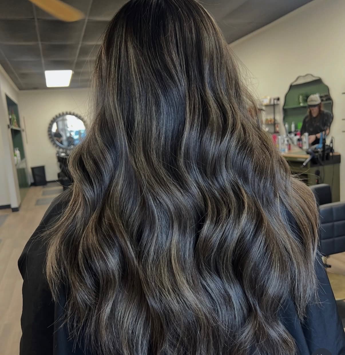 Dark brunette hair with silver and ash highlights styled in loose waves at The Hair Collective Oklahoma City